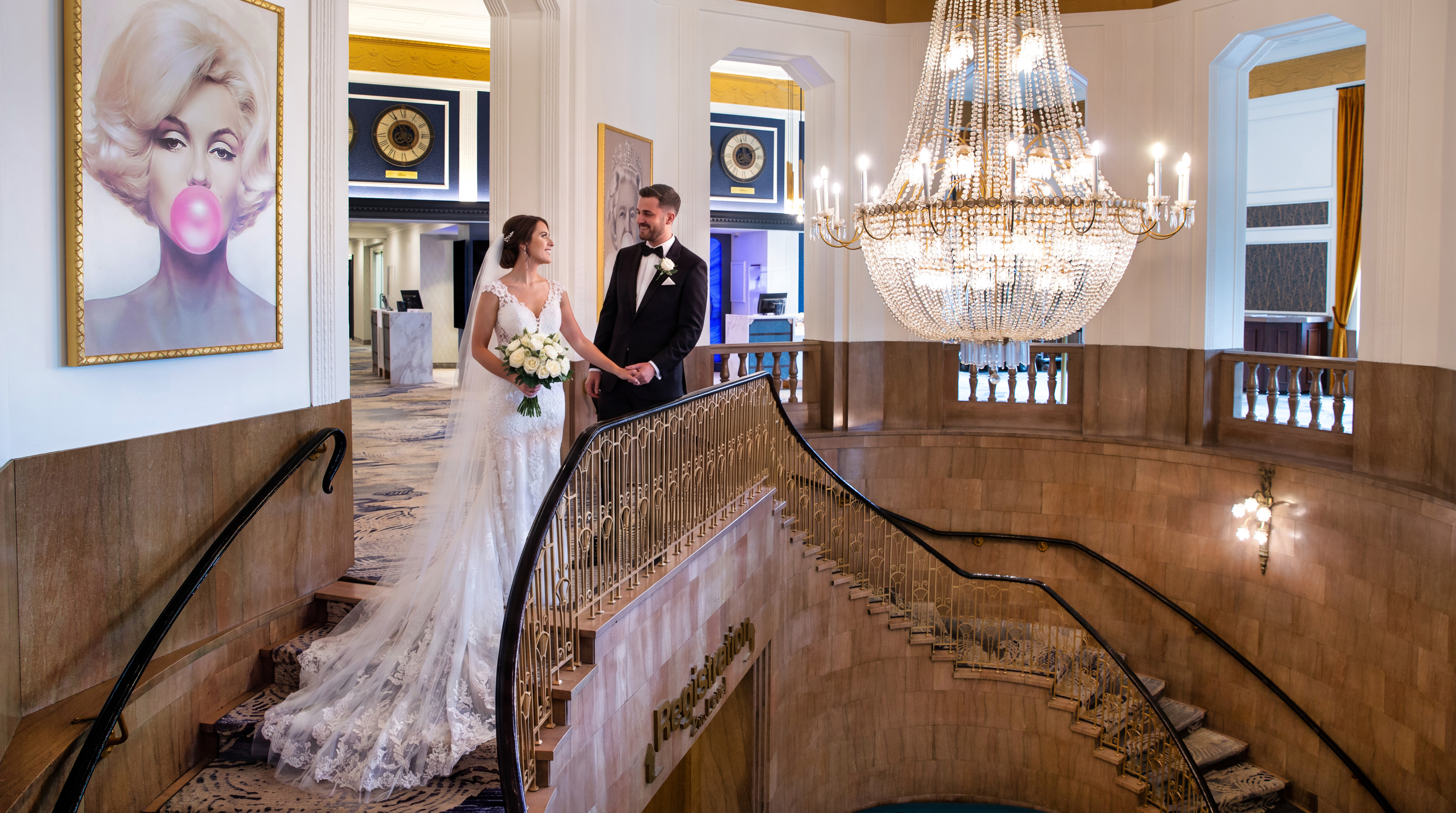 Grand Staircase Wedding couple on the grand staircase beneath the crystal chandelier at The Brock Niagara Falls